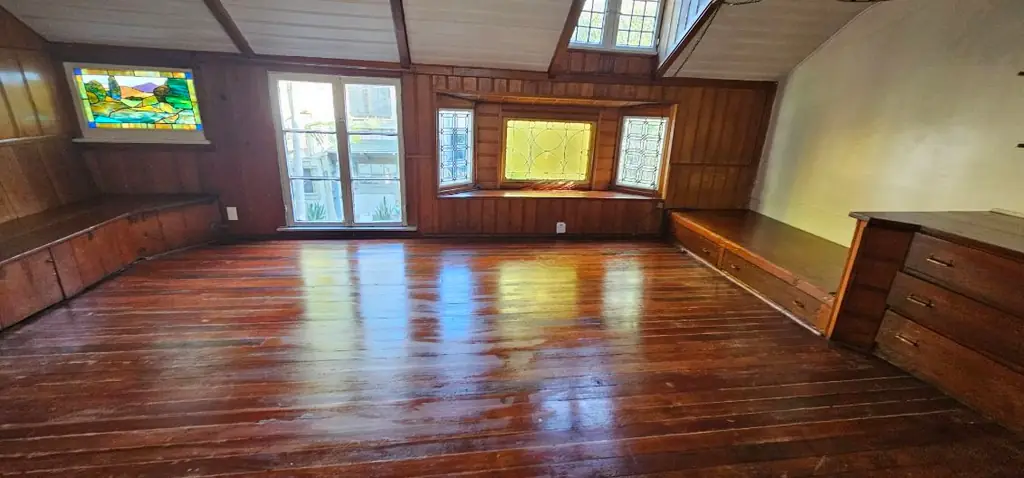 A wood-panelled room with a polished floor after cleaning