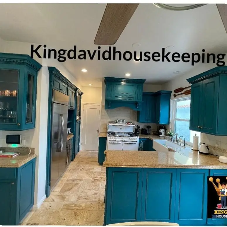 A teal kitchen with wiped counters and a clean stovetop