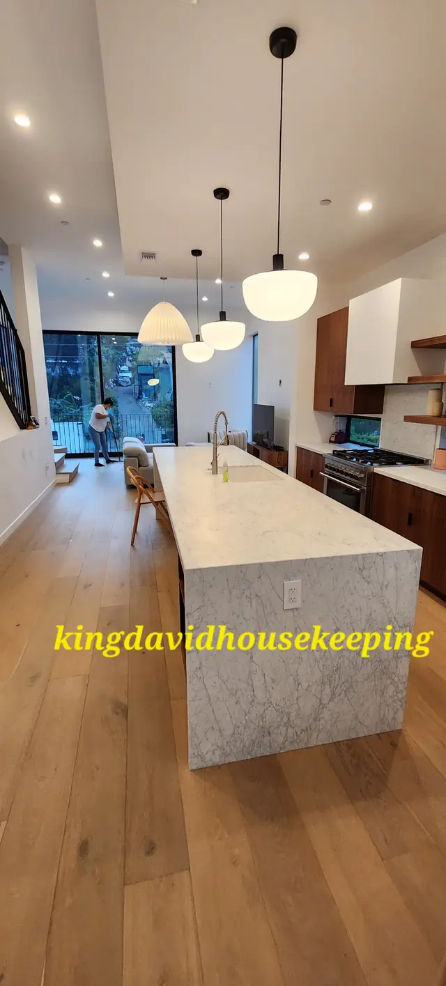 A tall view of a kitchen with pendant lights over a clear island