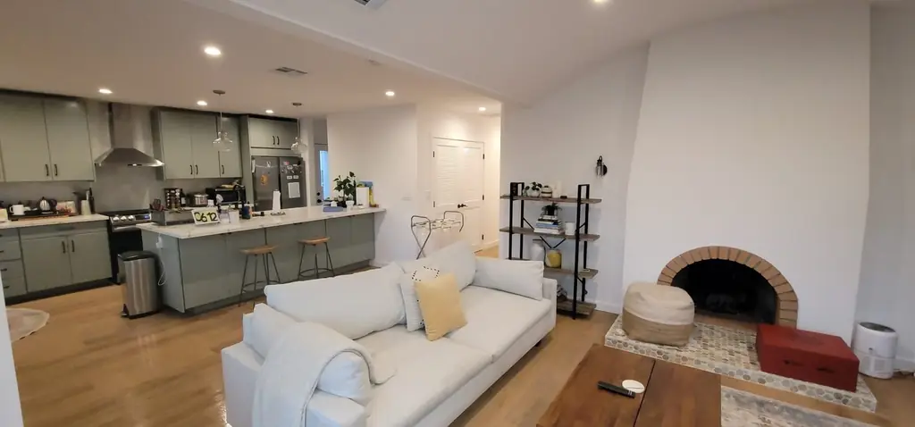 An open kitchen and living room with a brick fireplace, cleaned and set